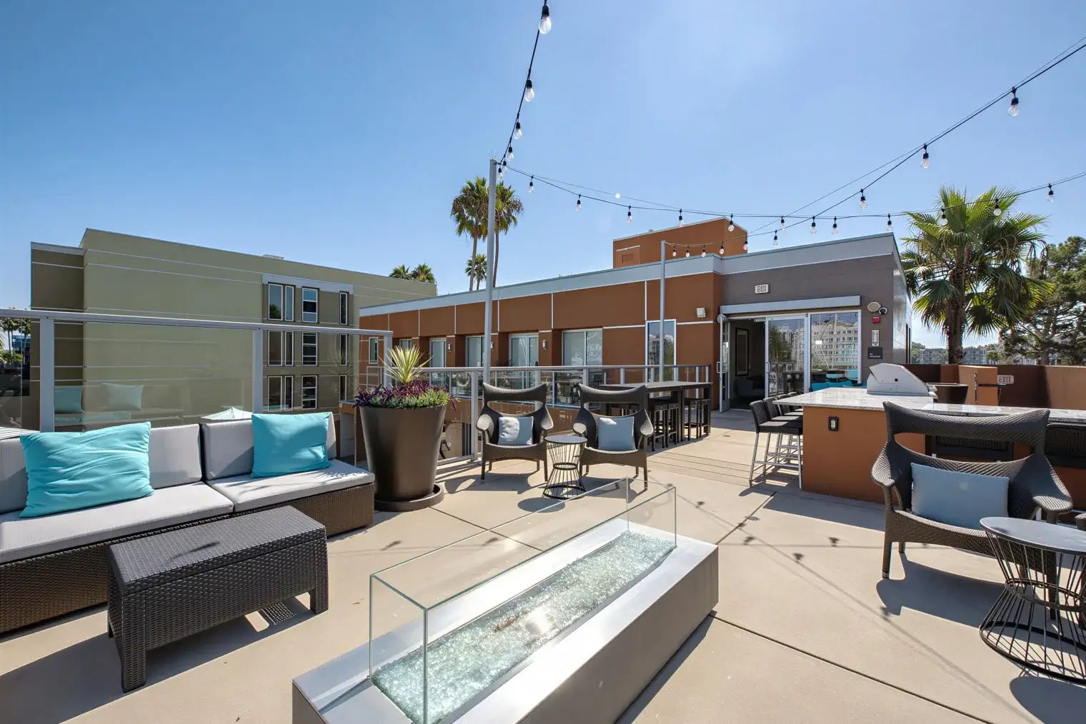 Outdoor rooftop lounge with firepit and seating at Harborside Marina Bay apartments